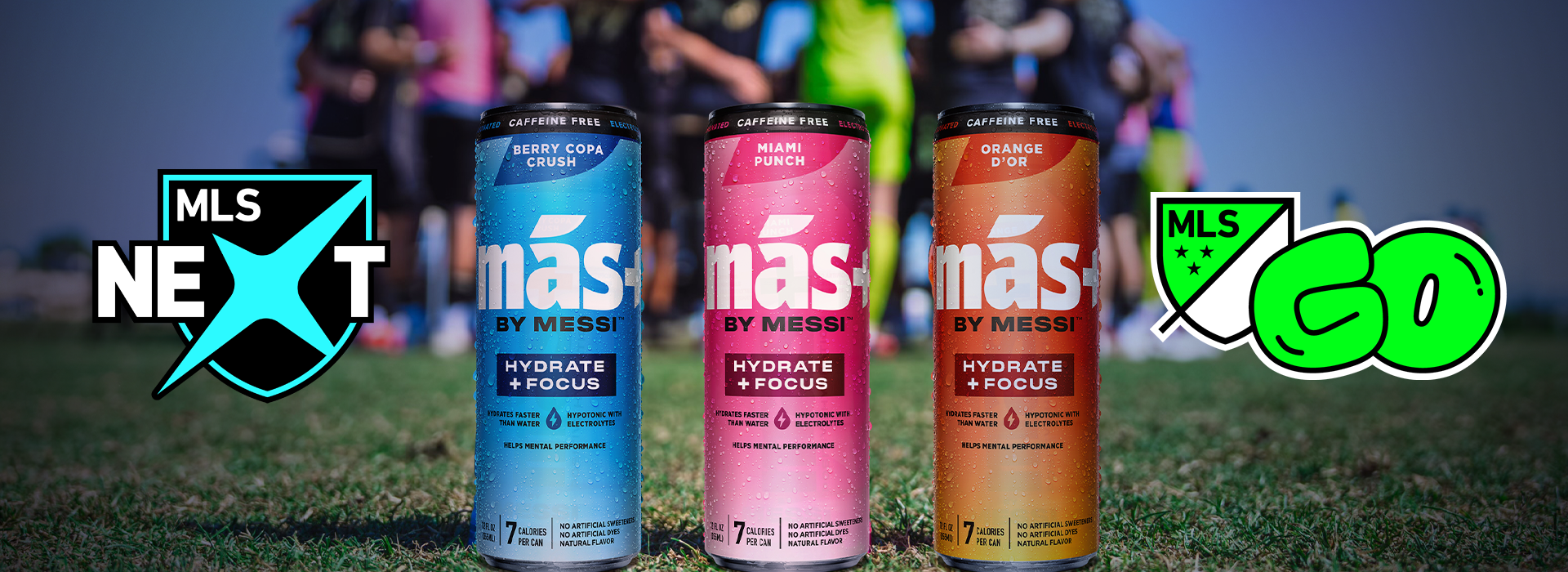 Three cans of 'más by Messi' drinks (Berry Copa Crush, Miami Punch, Orange d'Or) stand on grass with players blurred in the background. The MLS Next logo is on the left and the MLS GO logo is on the right.