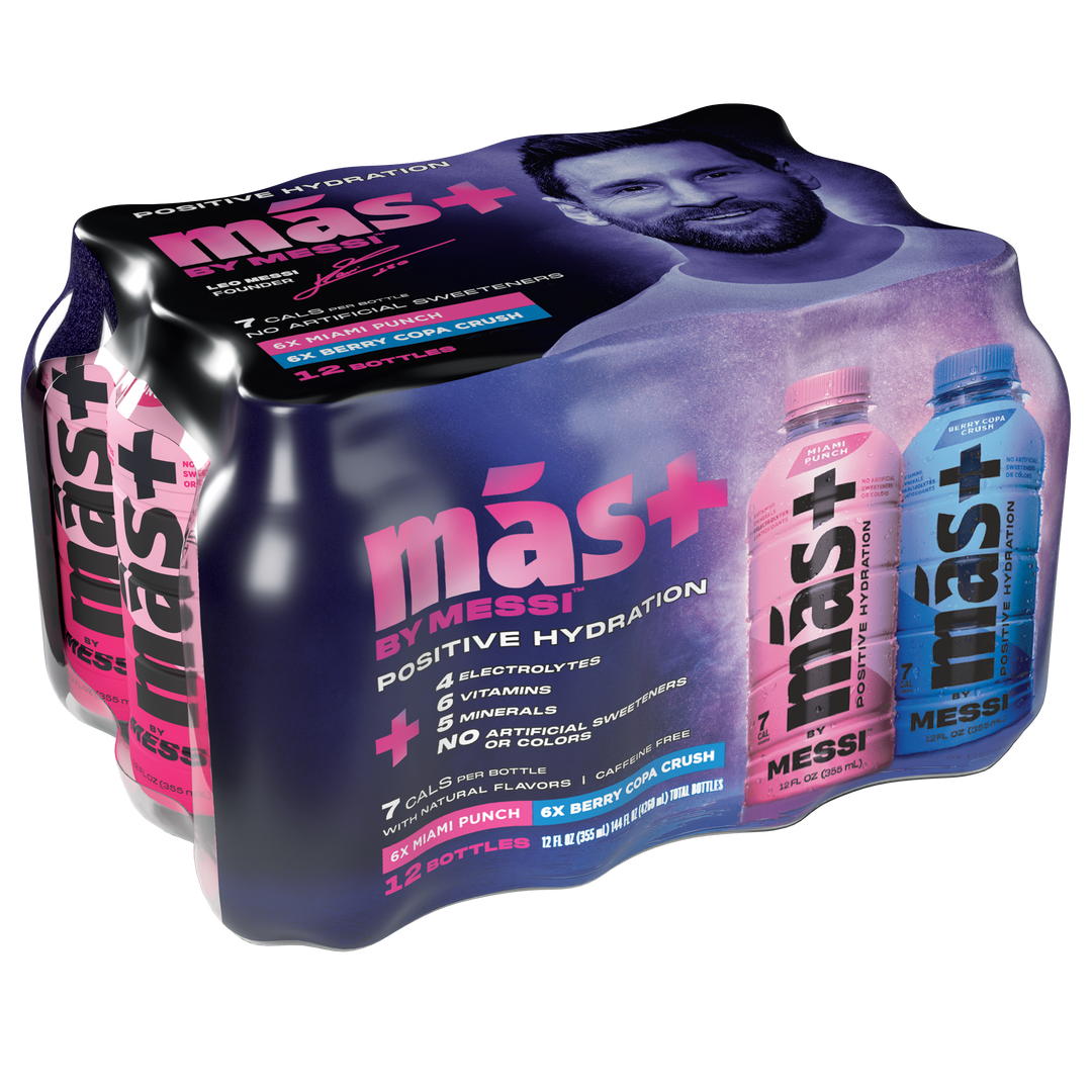 Packaging of más+ by Messi hydration drink 12-pack, featuring a dynamic design with Lionel Messi’s image and two front-facing bottles—one pink (Miami Punch) and one blue (Berry Copa Crush). The package emphasizes benefits like 7 calories, 6 essential vitamins, electrolytes, and no caffeine or artificial sweeteners. Sleek black background with bold, colorful branding conveys energy and performance.