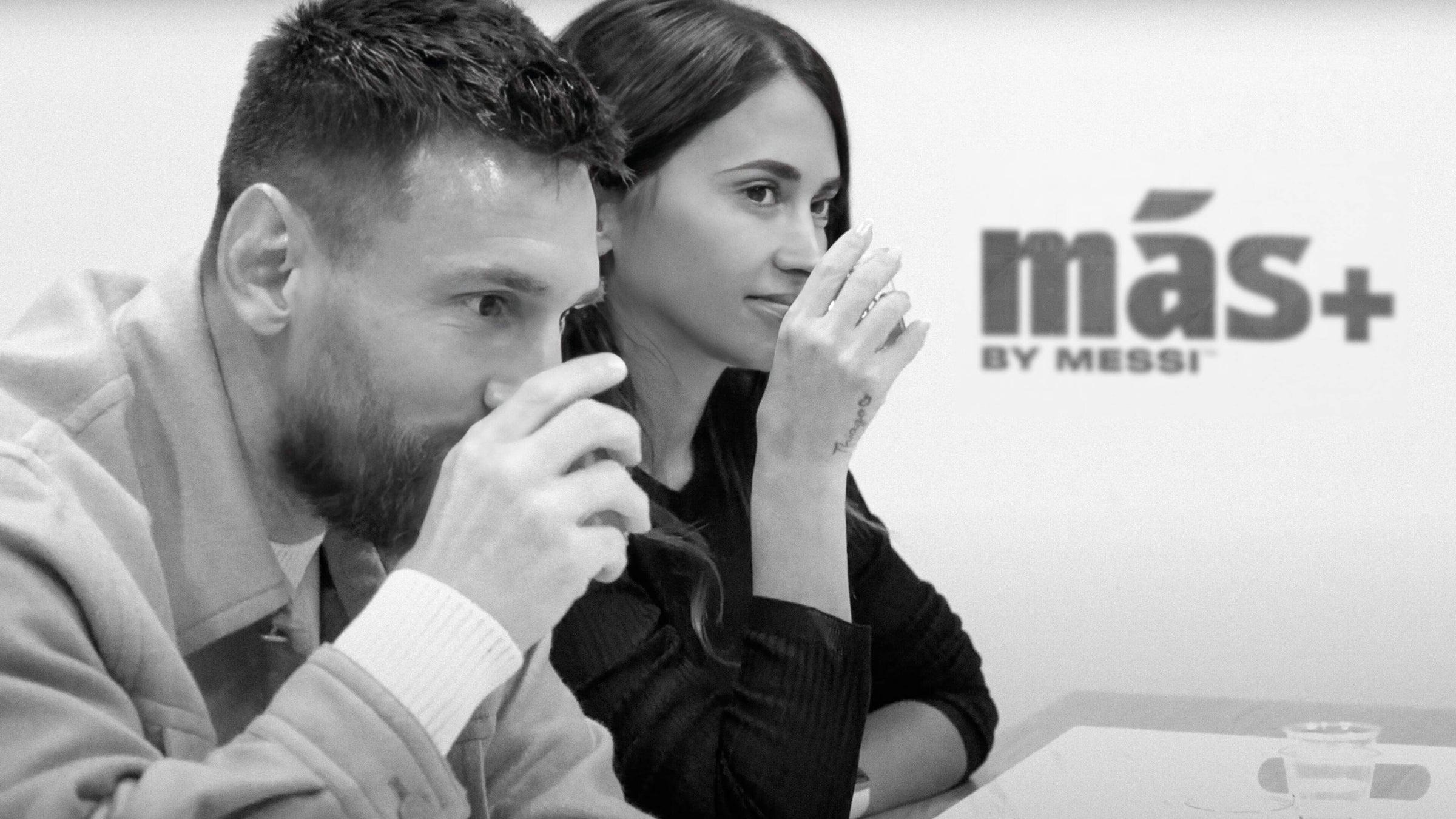A black-and-white photo of Leo Messi and Antonela Roccuzzo during a tasting session of Más+ by Messi hydrating drinks