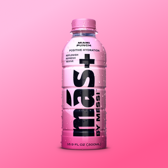 A 500 mL bottle featuring Más+ by Messi with Miami Punch flavor displayed against a pink background, emphasizing positive hydration.