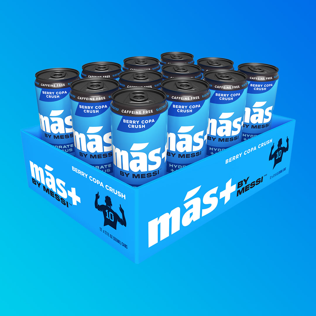 A blue cardboard tray holding twelve cans of Más by Messi Berry Copa Crush flavored, caffeine-free sports drink.