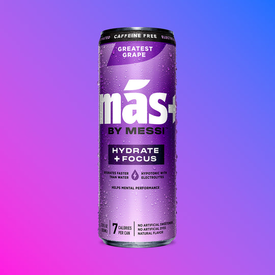 A single, condensation-covered can of Más by Messi Greatest Grape flavored, caffeine-free sports drink.