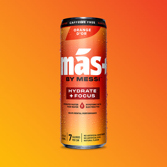A single, condensation-covered can of MÁS+ by Messi 'Orange d'Or' hydration drink against an orange-yellow background.