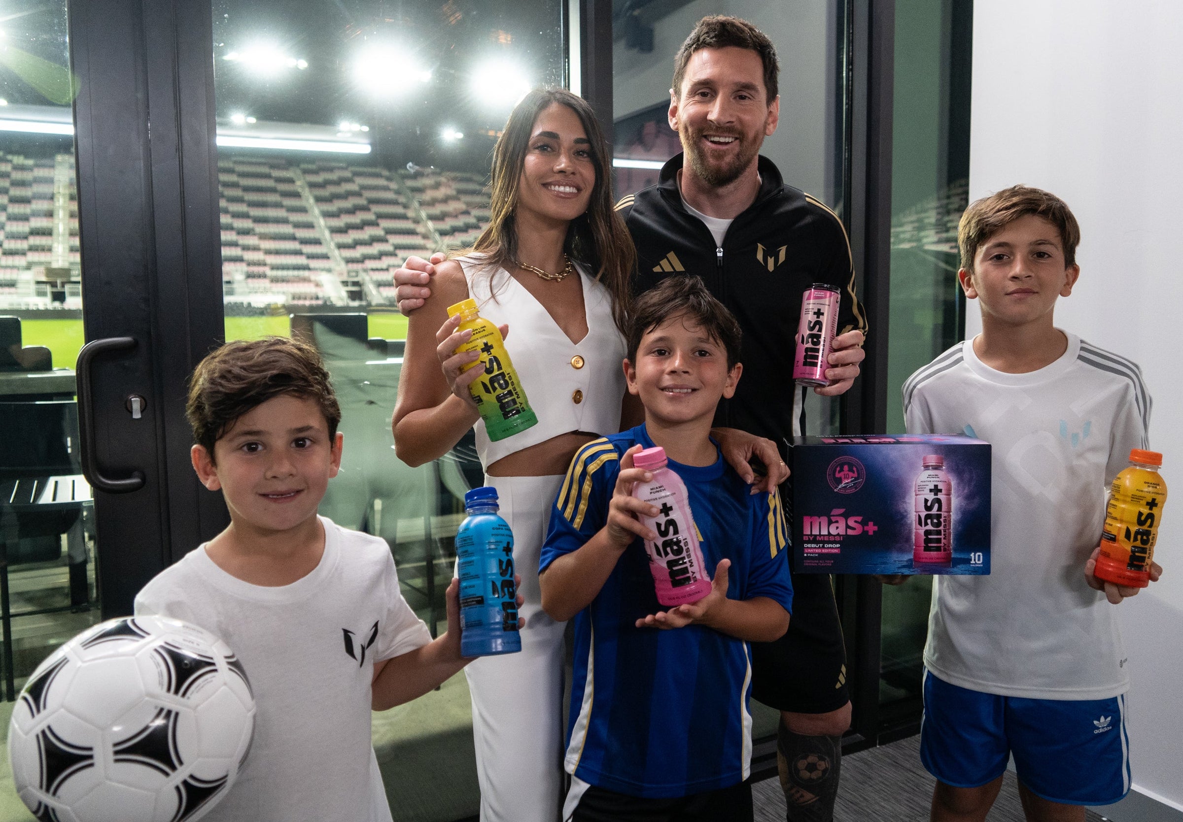 Leo Messi, his wife Antonela, and their three sons holding Más+ by Messi products.